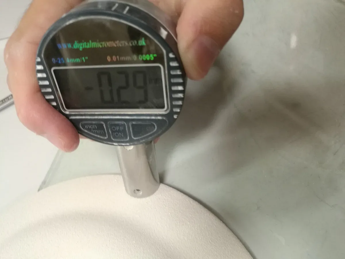 Digital micrometer gauge measuring the thickness tolerance of a physical production sample
