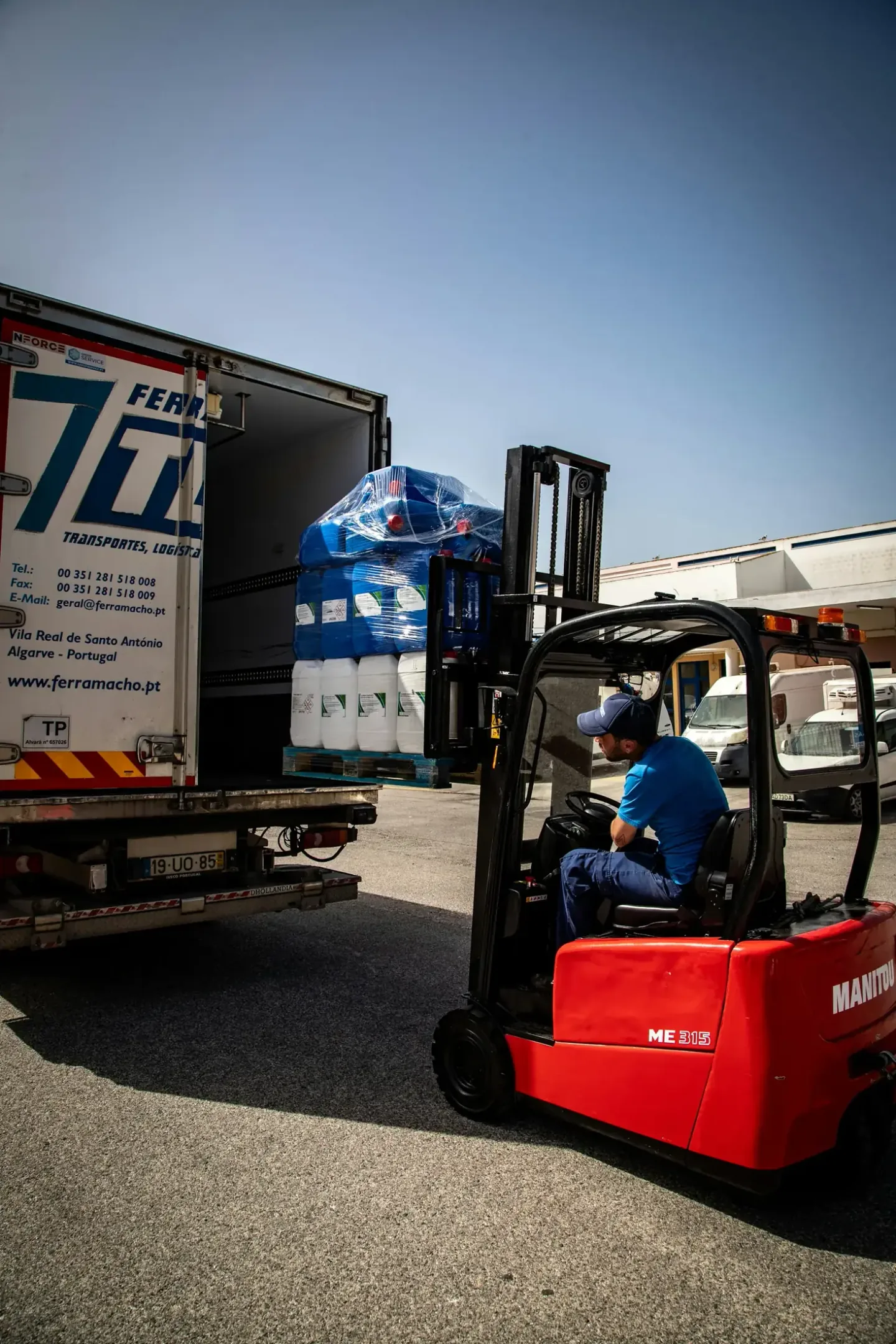 Forklift loading palletised cartons onto a commercial freight truck for inland delivery