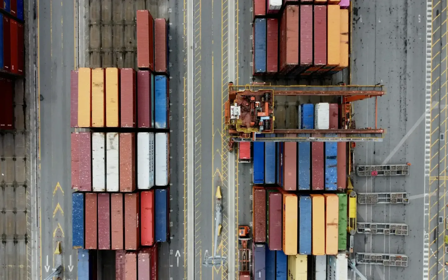Container ship and port cranes handling export containers at a daylight commercial terminal